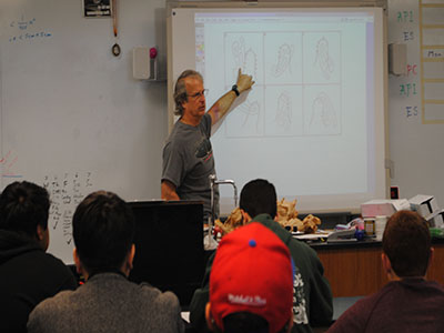 Teacher Mike Richards  explains to one of his Engineering Science classes the basics of building a sailboat.