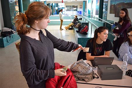 Junior Mandy Spiwak pays for the items she found after twenty minutes of thrifting.