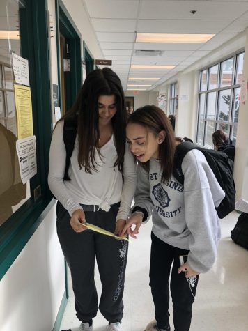 Juniors Meg Nelson and Sienna Rousse look over a class registration sheet and choose which classes they would like to take their senior year.