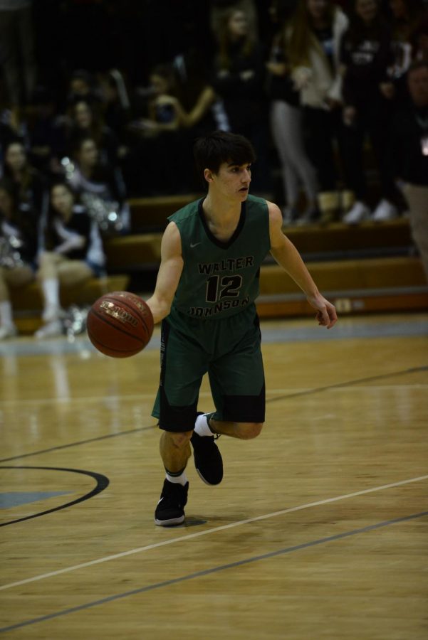 Senior captain Nick Bournias dribbles to the basket. Boys basketball had a 4-16 record this season and lost their first game of the postseason.