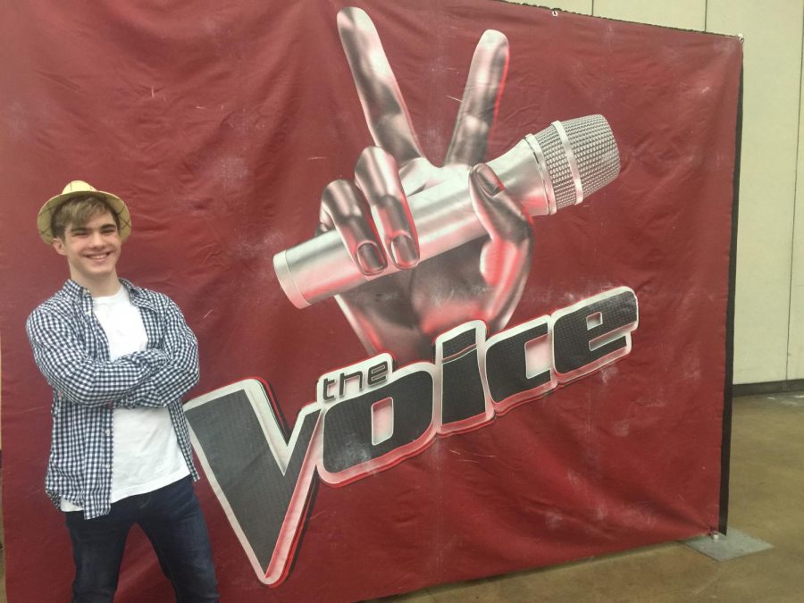 Jake Brown poses with The Voice banner at his audition. Little did he/the world know that he would soon take on the competition by storm. Photo courtesy of Jake Brown.