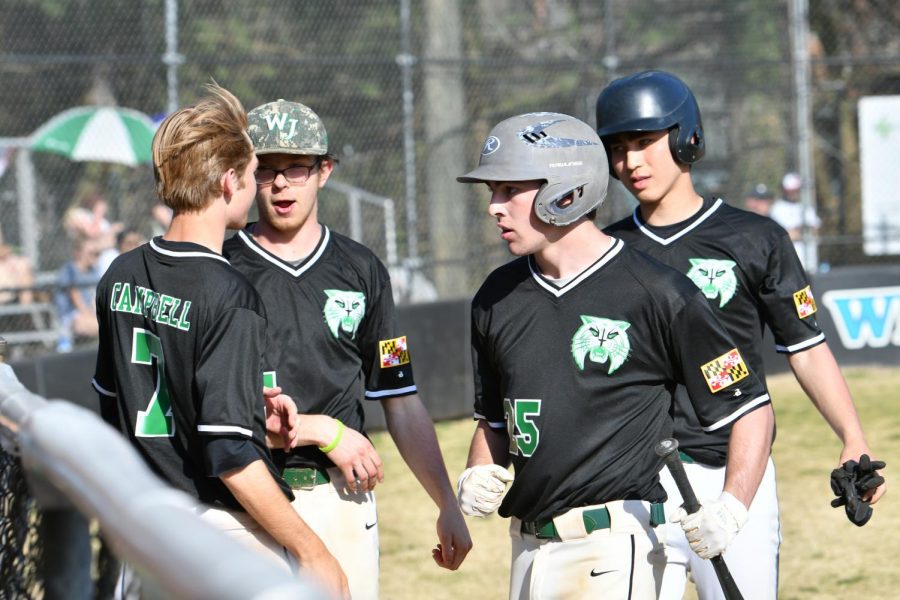 Seniors pitcher/shortstop Kyle Peterson, first baseman Connor Phelps, pitcher Kevin Good, and infielder Ian Rickles meet at the dugout after a successful inning. Photo courtesy of Imageflo.