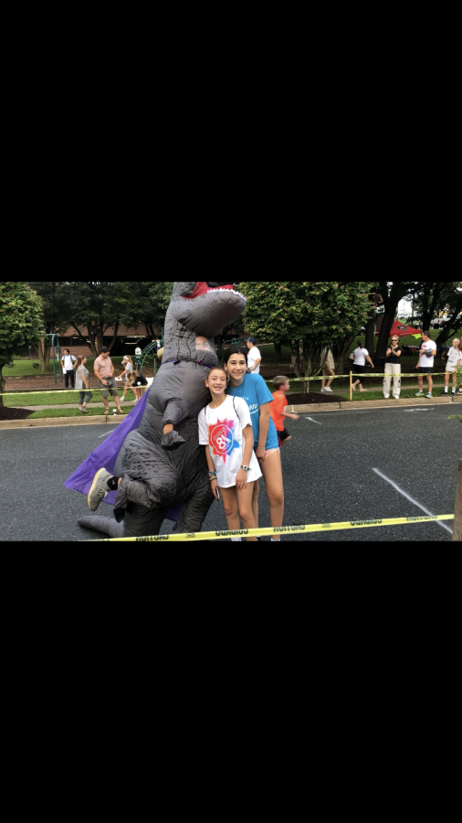 Middle school students Ila Gordon and Pearl Hoffman- Byer pose with one of the mascots of a sponser. Children and families wait at the finish line for their relatives and friends to finish the race. 