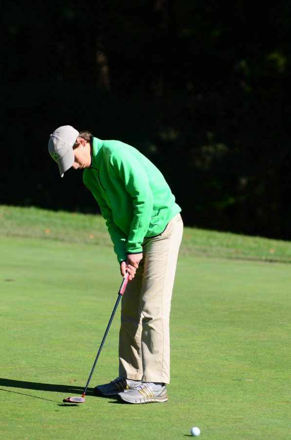 Sophomore Jake Griffin warms up for Day 1 of the state championships on the putting green. Griffin led the team with a score of 75 on the first day.