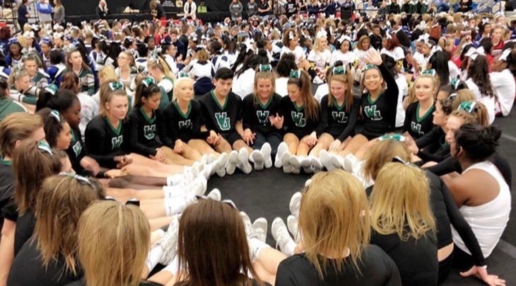 The cheer team sits in a circle for some last minute team bonding before their regionals performance. 