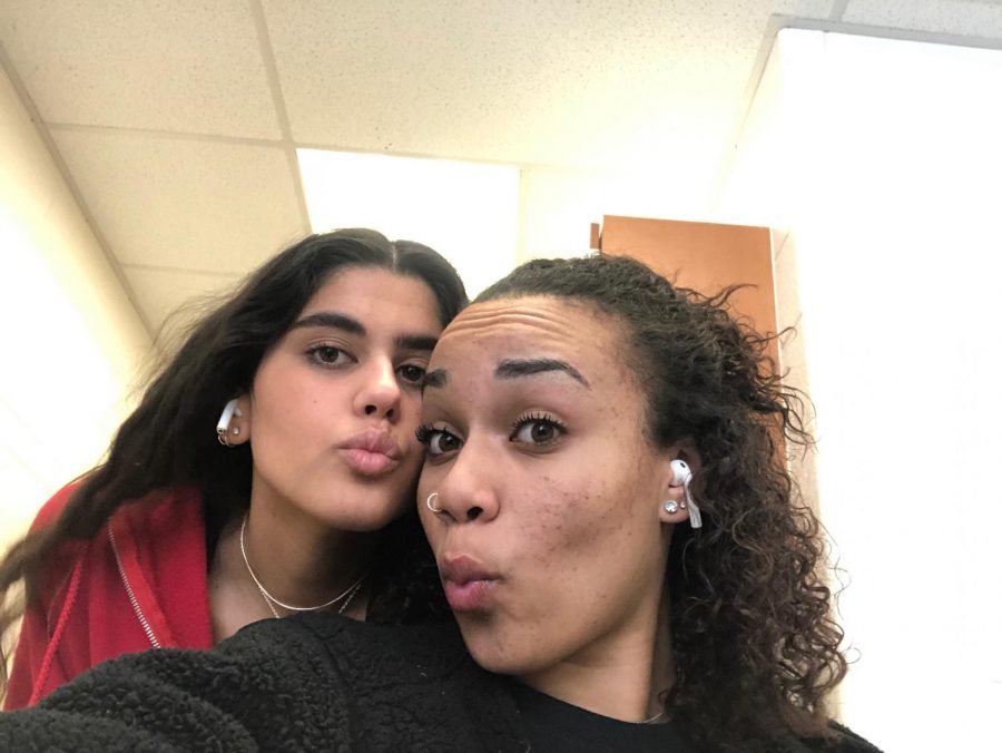 Seniors Karina Lee and Meg Nelson show off their Airpods in class. A lot of friends share their Airpods to listen together, and the wireless aspect of them makes sharing very easy. 