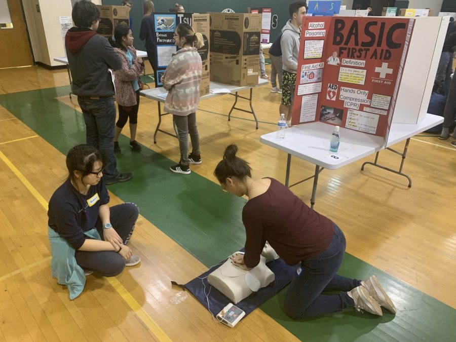 Two+students+practice+their+CPR+skills+to+demonstrate+the+importance+of+basic+first-aid+knowledge.+This+was+one+of+many+interactive+presentations+at+the+fair+that+taught+students+certain+health+skills.+