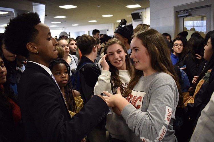 Junior Nate Tinbite talks to a Watkins Mill High School student as she congratulates him on becoming one of the final two candidates for SMOB. The hallways were filled with students excited about Tinbite’s campaign in the final stretch before voting on April 24.  