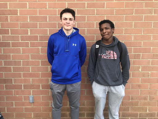 Junior Varsity defensive play Brody Ramirez (left) poses next to Varsity star Luke Hinds (right) before practice in 2018. Both wearing grey sweatpants.