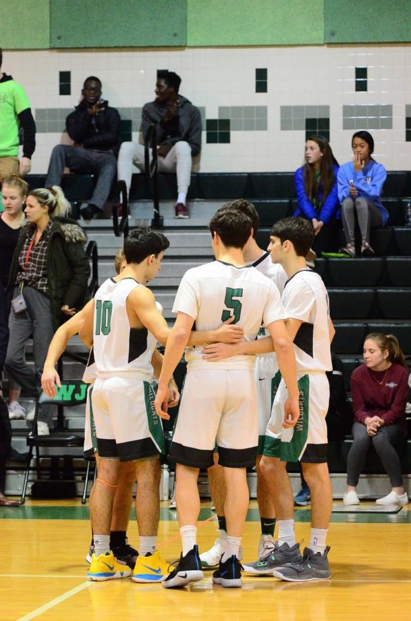 The varsity basketball team gathers before another crucial home game. After finishing first in their division and making it to regionals, the team looks to repeat that success in the fall. 