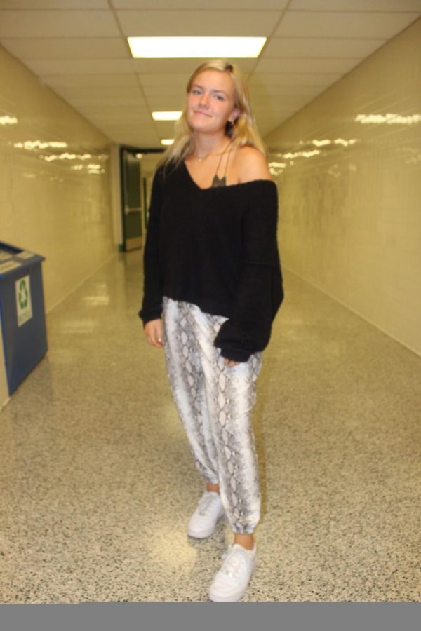 Abbey Malone is wearing a fluffy black sweater with snake print pants. She added a little more style with a lace Free People bralette.