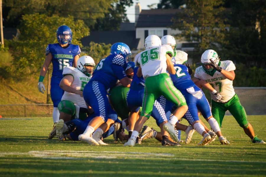 Number 85, sophomore Lucas Boiteux, piles onto Churchill players in an attempt to regain possession.