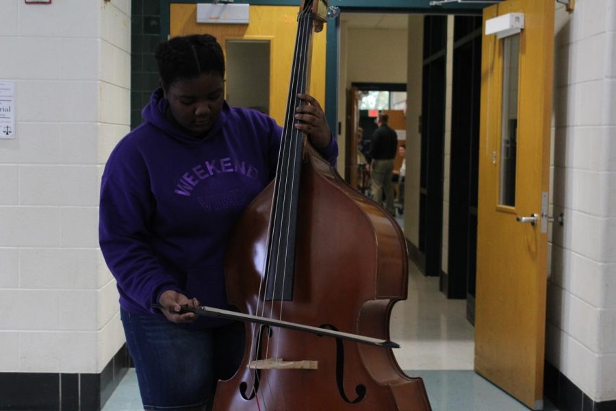 Semira Hill playing a bass outside the band practice room. Hill can play over half a dozen instruments ranging from the drums to the violin, and she is also a part of Madrigals, the highest level choir class WJ offers.