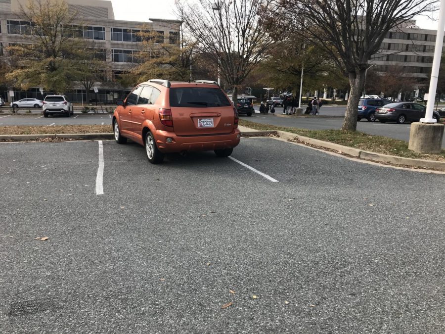 In the empty lot, this fall themed fake minivan is slightly off-center. Pontiacs are a rare sight, but a parking job this bad may be even rarer.