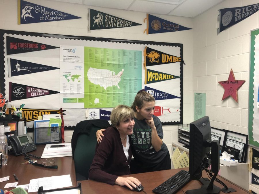 Ms. Evans shows senior Sophie Difrank information on the college shes planning on attending. Evans is always willing to lend a hand when it comes to finding the job or college thats right for you.
