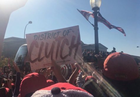 Fans hold a District of Clutch sign to catch the attention of players standing on the bus. It was so much fun. I love this team and I love the fans. Everyone was so excited and the energy was unbelievable. I was shocked to see so many people and their pride for the Nationals. -Eilis Cawley, senior