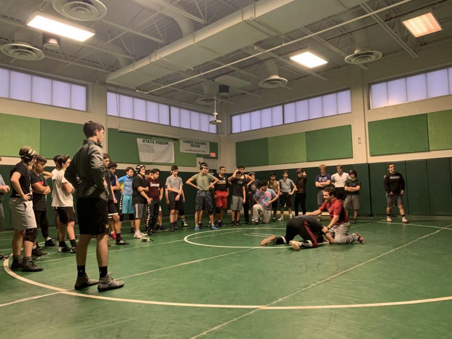 Coach Evan Silver and junior Joseph Meyer  show the team technique at their daily practices. Wrestling had a solid season last year and will look to continue their success.