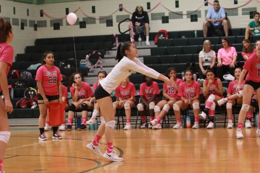 Senior Karina Yung hits the ball over the net in the Dig Pink game against Whitman. The game is annual fundraiser in October to raise awareness for breast cancer.