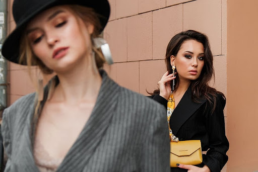 Two models are seen here sporting blazers and bold earrings. Gender-bending fashion trends are rising in popularity thanks to a huge 70s comeback.
