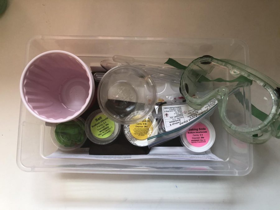 A lab kit featuring supplies like salt, baking soda, and lab goggles sits on the counter in junior Olivia Hermans house. Some teachers have prepared lab kits for students to take home so they can complete labs from a distance.