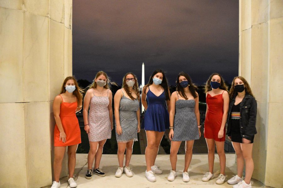 (Left to right) Seniors Nicole Uhl, Anne-Fleur Winter, Danielle Nevett, Ella Mochizuki, Sophie Kotlove, Emmie Maisel and Maggie Lieberman pose for a photo in their dresses and masks at the Lincoln Memorial.