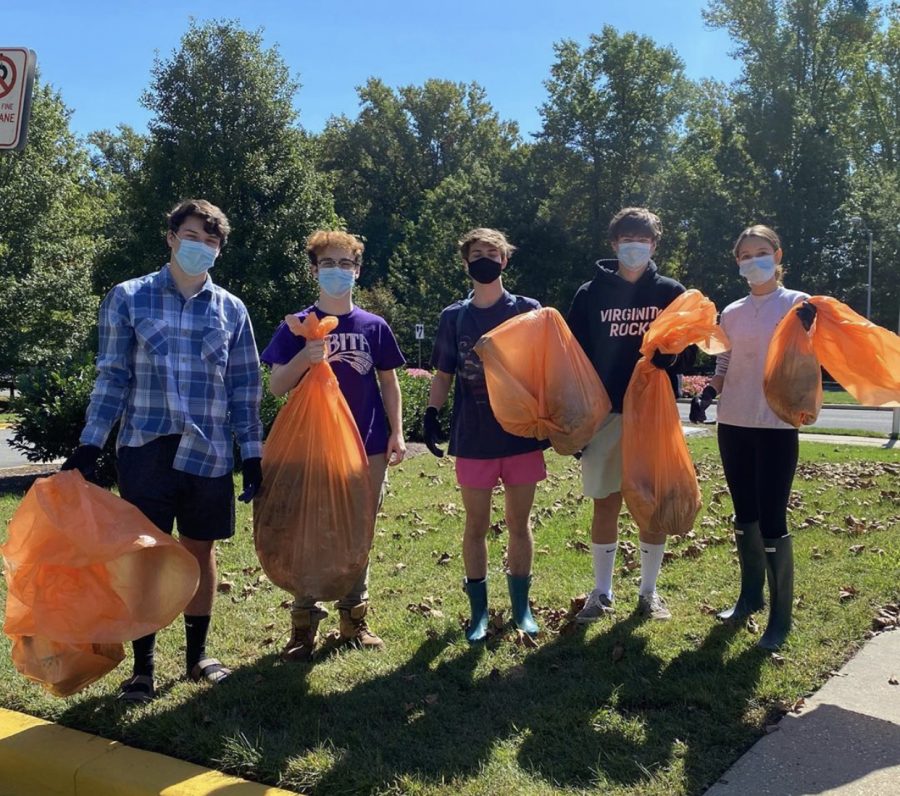 (From left) Juniors Caeden Babcock, David Bowers, Charley Carr, Will Wise and Sophia Carrasco pose with trash collected from a Rockville stream. Members of the Go Green club partake in many local volunteer activities to better the environment.