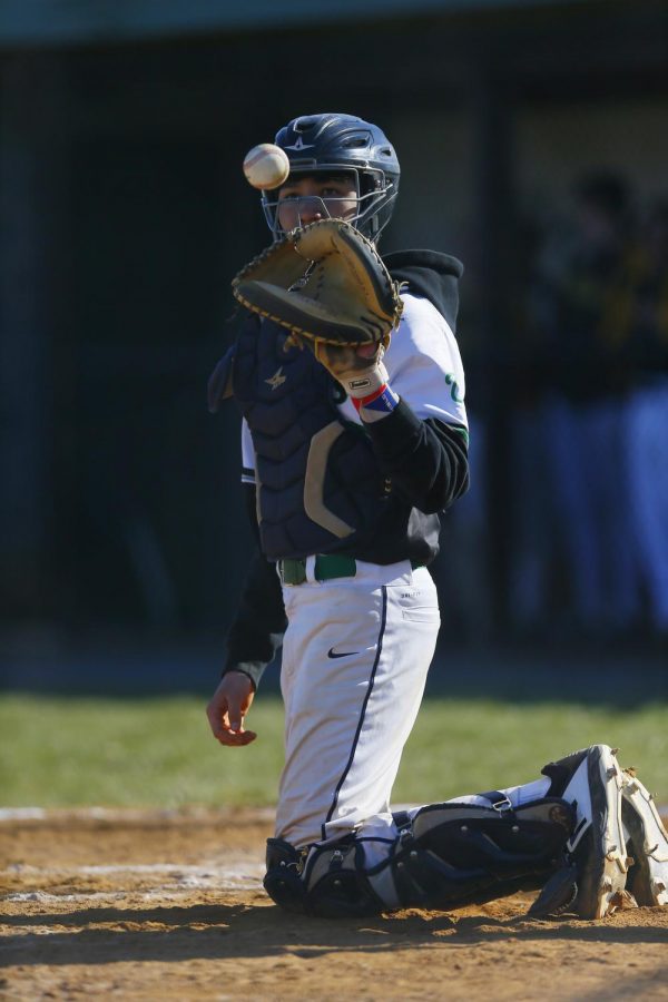 Senior Elias Eberhart catches the ball thrown back to him by the coach. Spring athletes have different views on the upcoming season.