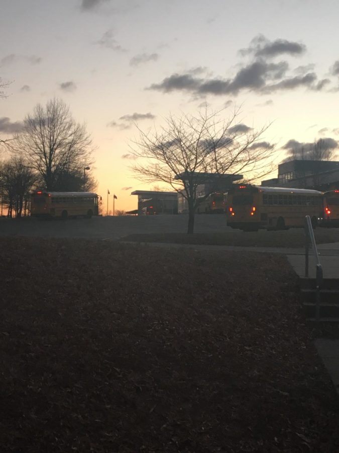 Buses drop off students as the sun rises over Walter Johnson High School. For the class of 2021, this scene may occur for another year.