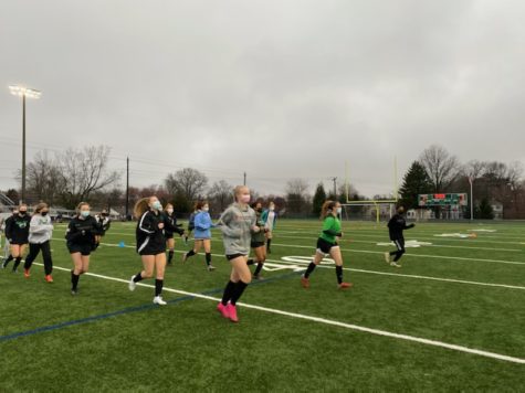 Girls varsity soccer completes their warm up jog before their game against BCC on April 24. The Wildcats lost 1-0 in overtime.