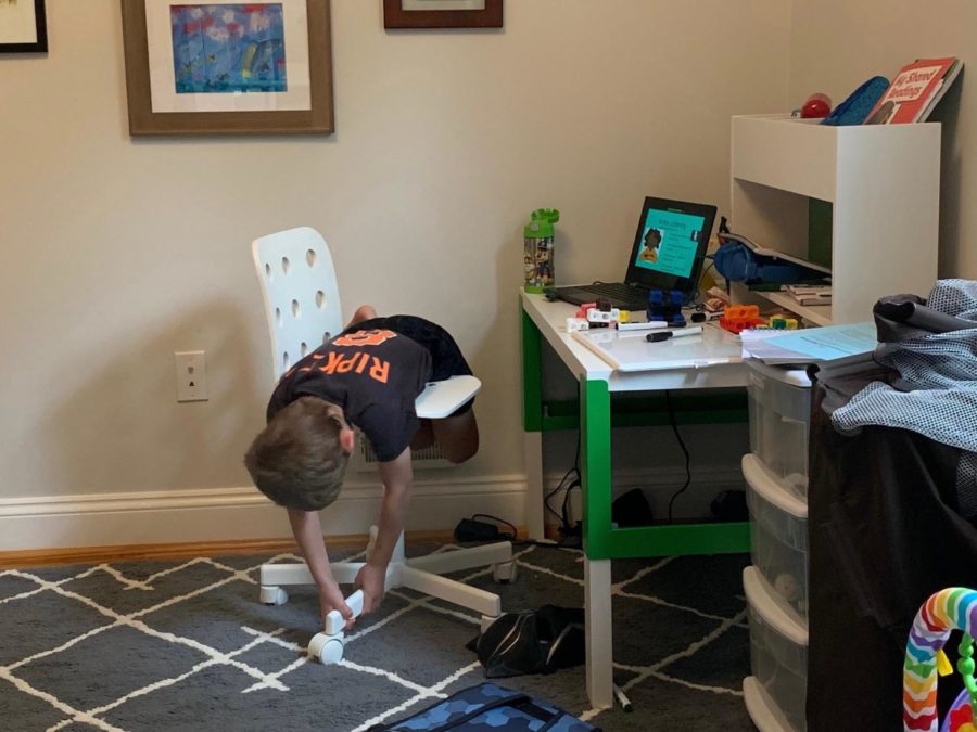 Kindergartener+Sam+Werfel+plays+on+his+chair+as+he+listens+to+his+teacher+during+virtual+school.+Focusing+during+online+learning+has+been+a+challenge+for+many+young+students.