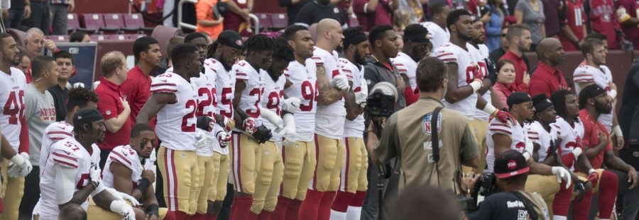 Some members of the San Francisco 49ers kneel during the National Anthem before a game against the Washington Football Team in 2017 in Landover, Maryland.
