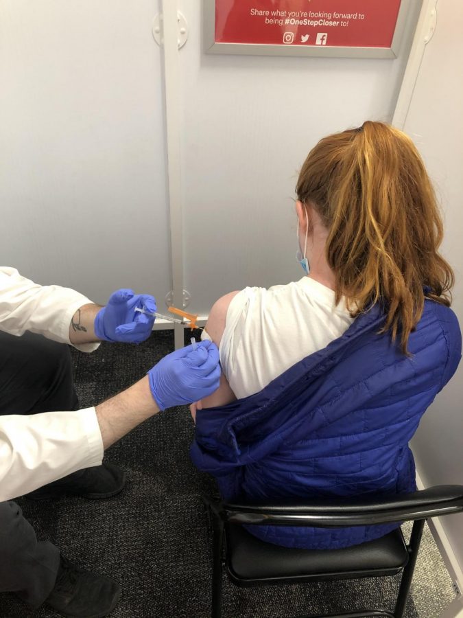 Junior Caroline Stewart gets her shot covid vaccine. Most students, ages 16 and up, have taken initiative to get vaccinated while younger students are just now able to get the vaccine.