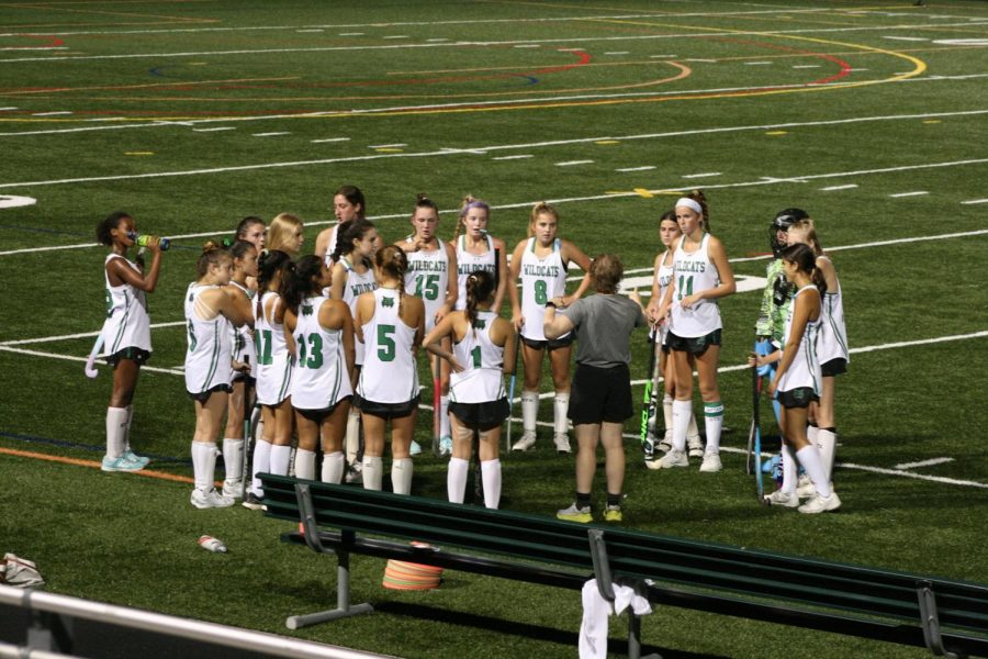 Coach Hannah Teicher plots a course-of-action with the entire field hockey team during half time. The team listened with the hopes of growing their lead.