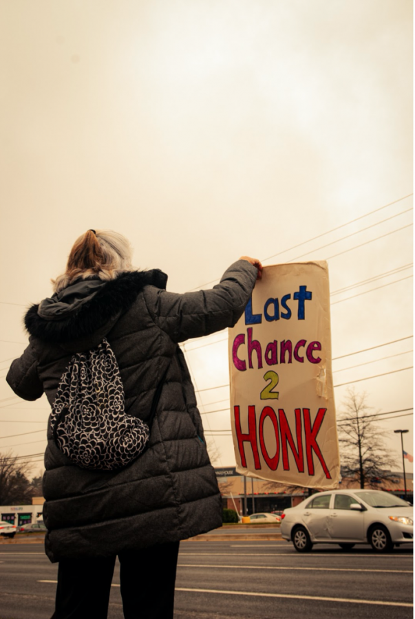 A pro-lifer stands on Old Georgetown Road holding a sign in defense of the cause. Protesters like this individual arrive outside the clinic daily and are fairly adamant about making a stand.