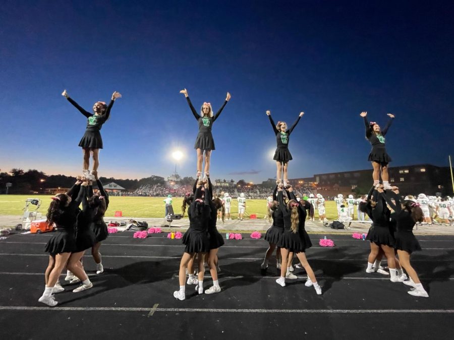 The cheer team hypes up the crowd at an away football game. From left to right, Gigi Elizabeth, Ava Franke, Tati Rivero, and Laura Mata. WJ cheer does this at every game and is a big reason why WJ has the best student section in the county.