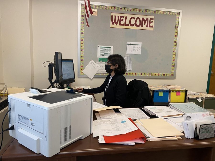 Maria Aliaga works on her computer, sorting out forms for students. Aliaga sends student forms and documents to Colleges.