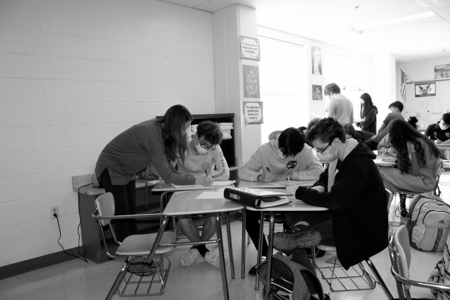 Math teacher Erin Hall assists students with classwork. Hall is one of the more engaging teachers seen in school and tends to leave the promethean board to give 1-on-1 help.