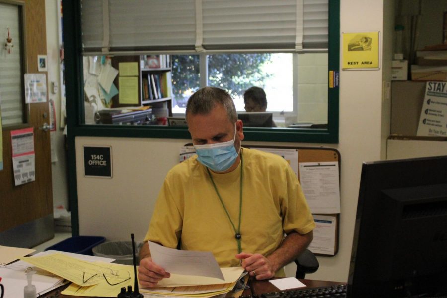 School Health Room Technician, Daniel Yankie observes the symptom sheet given to him by a student. When students go to the nurse feeling ill, they are now supposed to bring this symptom sheet with them to display their symptoms.