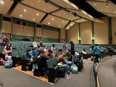 Symphonic Orchestra students prepare for a rehearsal in the auditorium for their upcoming winter concert. Practice in the auditorium is especially useful this year as many students have not had experience playing live there.