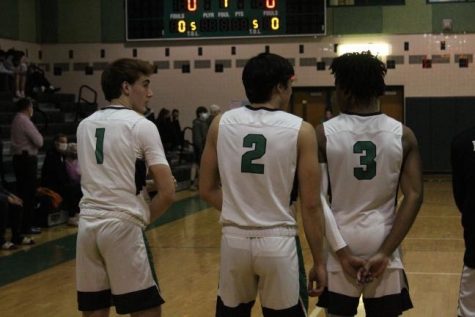 From left to right: Seniors Jack McGuire, Jackson Van Wagener and Immanuel Harper line up for the singing of the national anthem. They went on to lead the team to a victory over Northwood on Tuesday, Dec. 14.