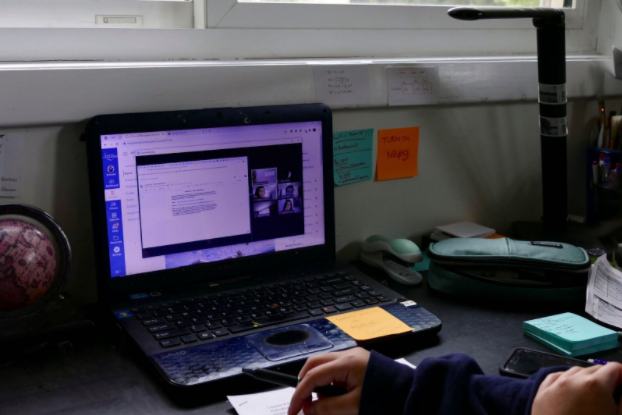 WJ student takes notes as teacher lectures over zoom.