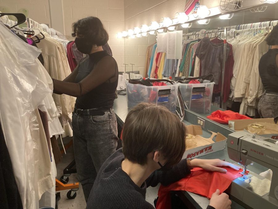 Sophomores+Adam+Dincin+and+Neena+Tavik+prepare+costumes+backstage.+It+can+take+anywhere+from+1+to+2+hours+to+make+each+costume+for+the+show.