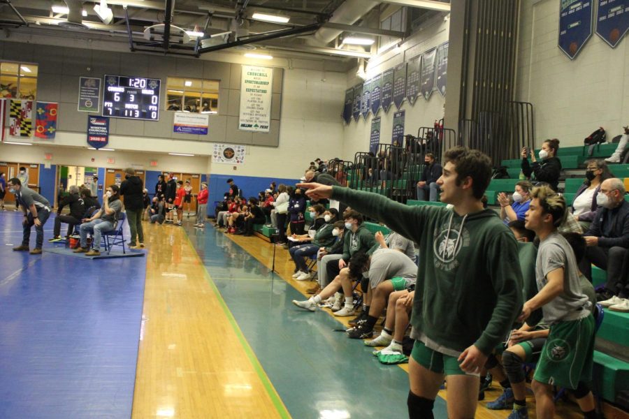 Senior Alex Ghaffari supporting his fellow wildcat wrestler on the mat by calling out moves that could aid him in winning against the Churchill wrestler. The coaches kind of give us freedom as individual wrestlers cause if you want to succeed you have to want it yourself, Ghaffari said.