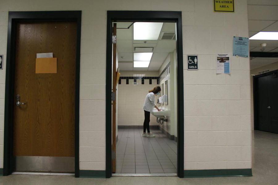 Junior Omer Bezherano washes her hands in the girls G-floor gym bathroom. The bathroom doors, at this bathroom and others, are open at any time, and anyone walking by can see into them.