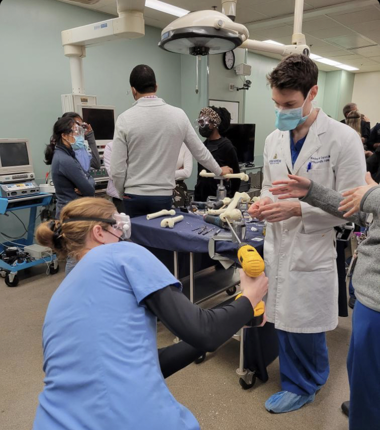 2017 WJ graduate Cami Lingenfelter (left) practices placing intramedullary nails during an orthopedic surgery workshop with the help of a resident physician (right). These workshops help her explore specific areas in biology and determine what type of doctor she’d like to be.