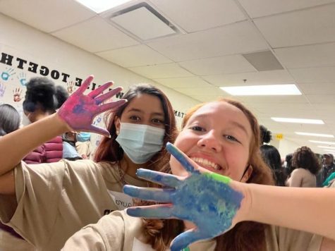 Juniors Victoria Rojas and Laura Silva put their handprint on the wall as one of the many activities at the retreat. The Minority Scholars Program wanted to convey the message of standing together as one and by doing that they asked all the participants to put their handprint on the wall.