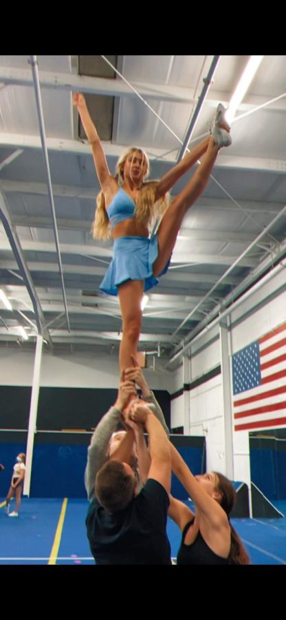 Junior Ava Franke is shown flying at her All-Star cheer practice. She is pulling a heel stretch at the extension level, which is a very difficult skill to conquer in the air. Flying is super scary, but it is also the best feeling ever, Franke said.