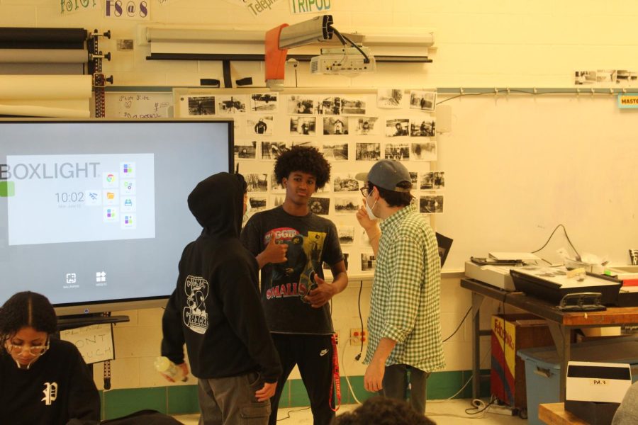 Photo teacher Sergio Stryker discusses the plan for the final project with freshmen Fraol Kebede and Vesal Varzagan.