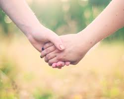 A couple holding hands before their long distance journey begins.