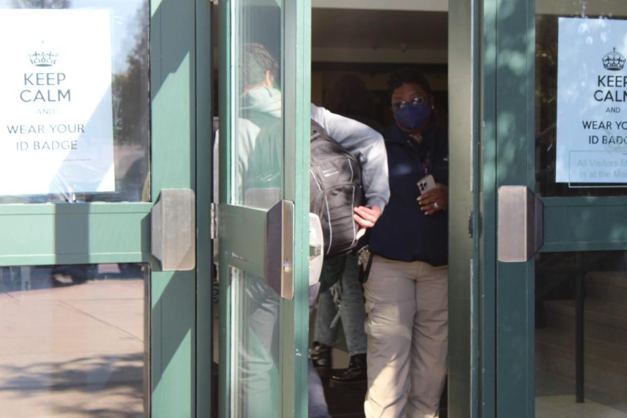 Security guard Marlene Smith checks a students ID upon entry at the auditorium entrance. The entrance, which is located near the student lot, has become one of the most crowded entrances in the school.